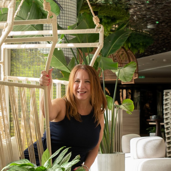 Christine Earls smiling in a plant-filled resort lounge